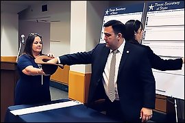 Deputy Secretary Esparza placing his hand into a hat to randomly draw a proposition to determine the order. 