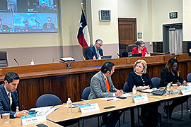 Secretary Nelson and Dr. Marco Gonzalez sitting at a table speaking with each other.