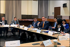 Secretary Whitley sitting at a long desk with other BTAC members. 