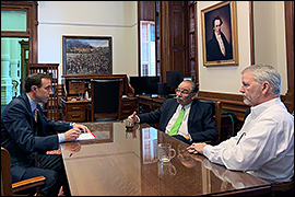 Secretary Whitley sitting at a desk with both state party chairs. 