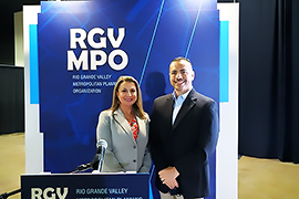 Secretary Hughs iand Pharr's Mayor stand in from of the RGV MPO sign.