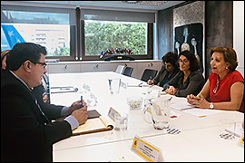 Secretary Pablos sitting at a desk across from other officials. 
