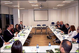 The delegation sitting around a desk in a conference room.
