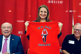 Secretary Hughs holding a W.B. Ray t-shirt